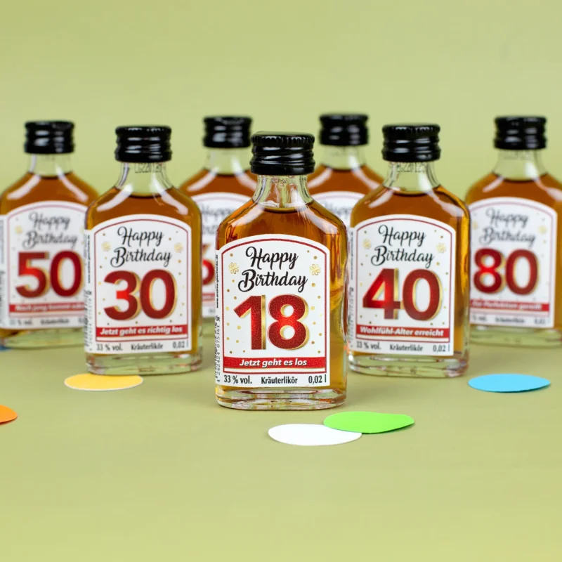 Miniatur-Kräuterlikörflasche „Happy Birthday 18“ vorne, dahinter weitere Flaschen mit Geburtstagszahlen 30, 40, 50, 70 und 80